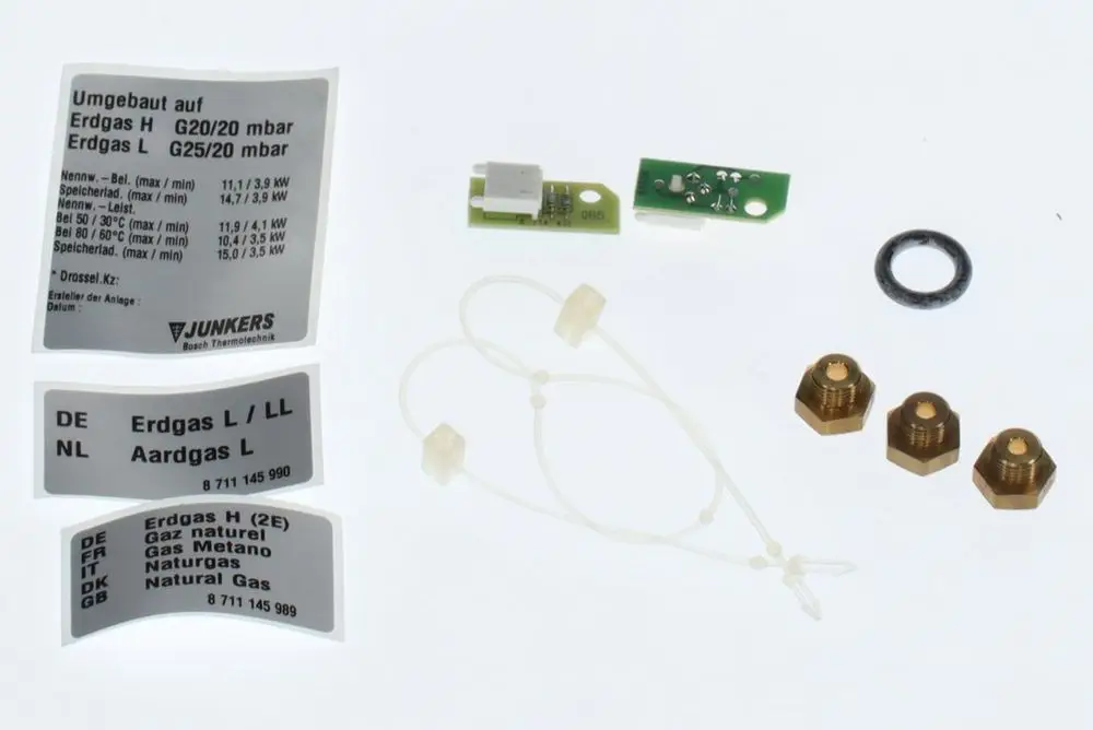 Bosch Gasumbau-Kit mit verschiedenen Komponenten wie Gaskennzeichnungen, einer Platine, Dichtungen und Anschlussstücken für die Umrüstung auf Erdgas.